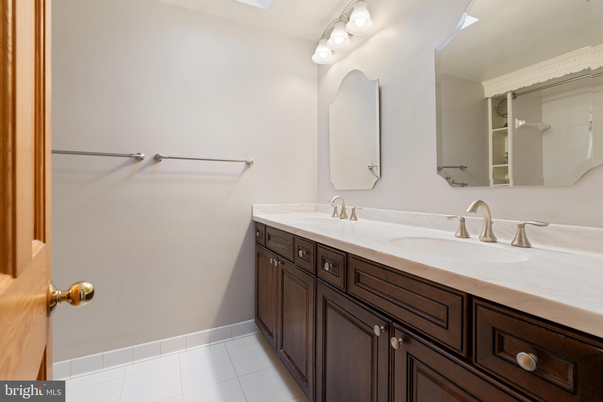 119 East Padonia Road Lutherville-Timonium, MD 21093 - Photo 20 of 39 a bathroom with a double vanity sink a and a mirror