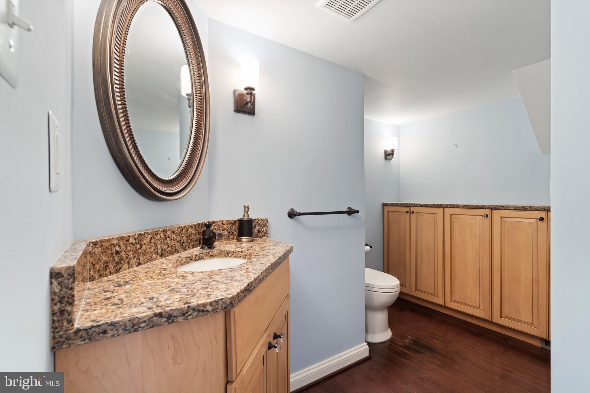 119 East Padonia Road Lutherville-Timonium, MD 21093 - Photo 30 of 39 a bathroom with a granite countertop toilet a sink and a mirror