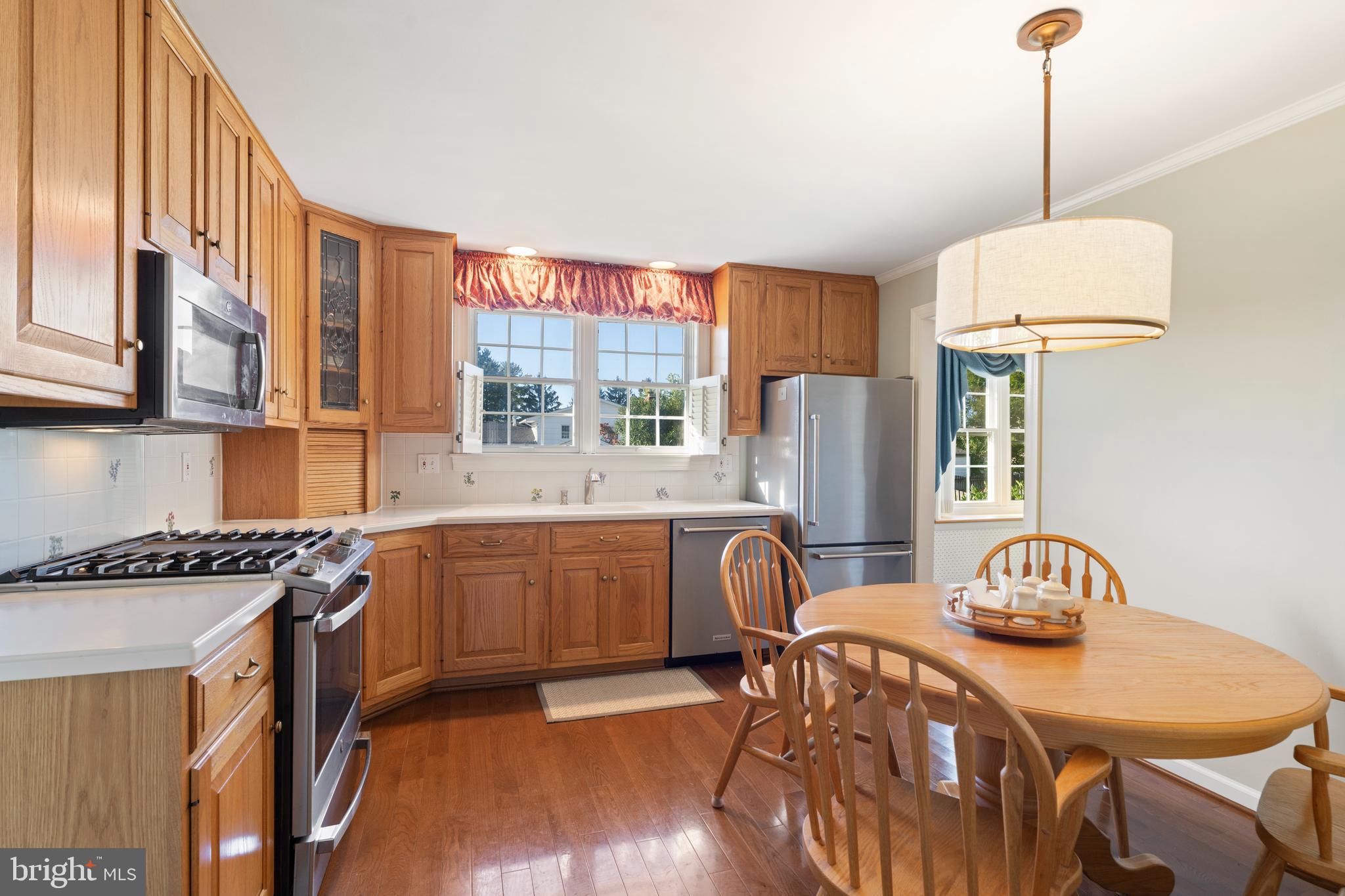 119 East Padonia Road Lutherville-Timonium, MD 21093 - Photo 7 of 39 a kitchen with stainless steel appliances granite countertop a stove a refrigerator a kitchen island a dining table and chairs with wooden floor
