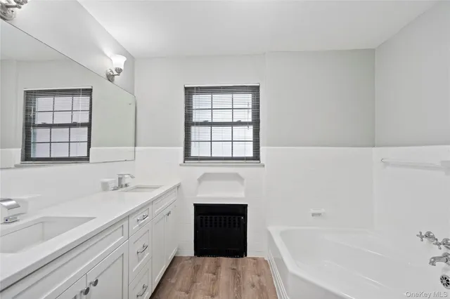 a bathroom with a sink double vanity granite tub and a mirror