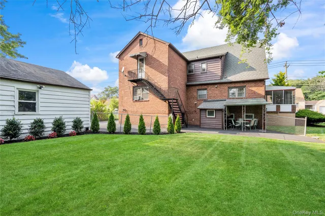 a view of a big house with a big yard and large trees