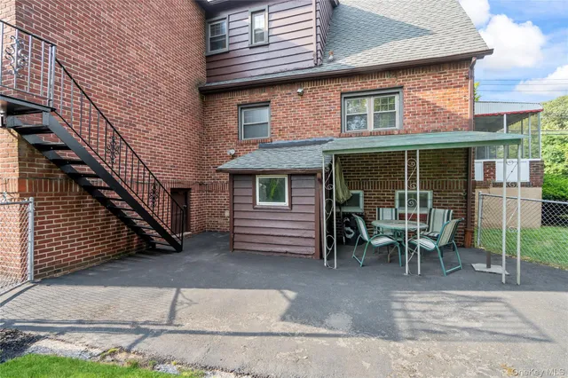 a view of a house with a patio and a yard