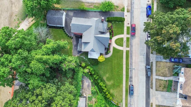 an aerial view of house with outdoor space and trees all around