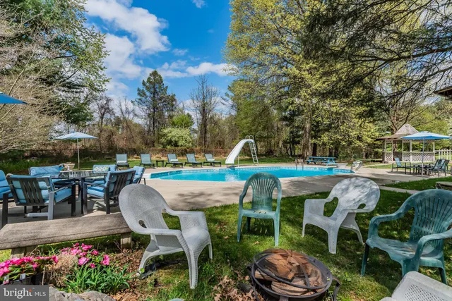 a dining hall with stainless steel appliances kitchen island granite countertop a dining table chairs and view living room