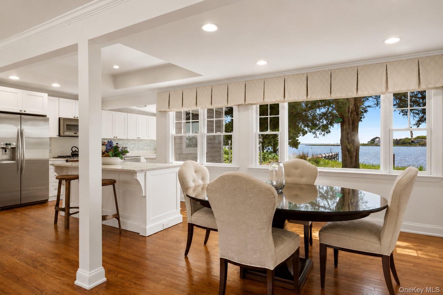 65 Shore Road Westhampton, NY 11977 - Photo 10 of 24 Dining area featuring expansive windows, water scenery, wood-finish flooring, recessed lighting, and crown molding