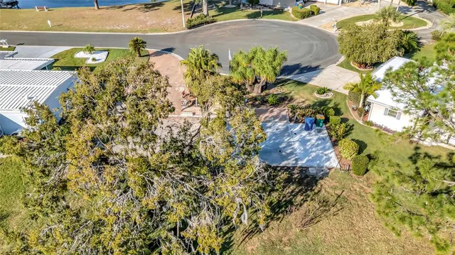 an aerial view of a house with a yard and large trees