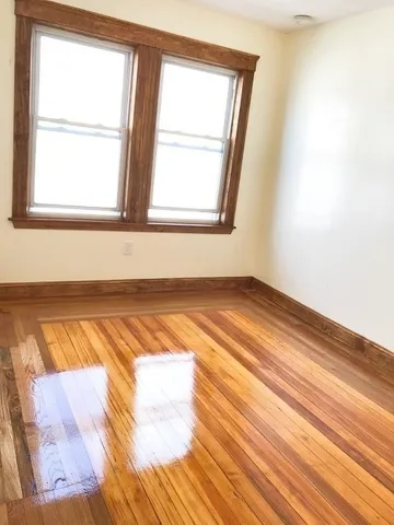 a view of a room with wooden floor and a window