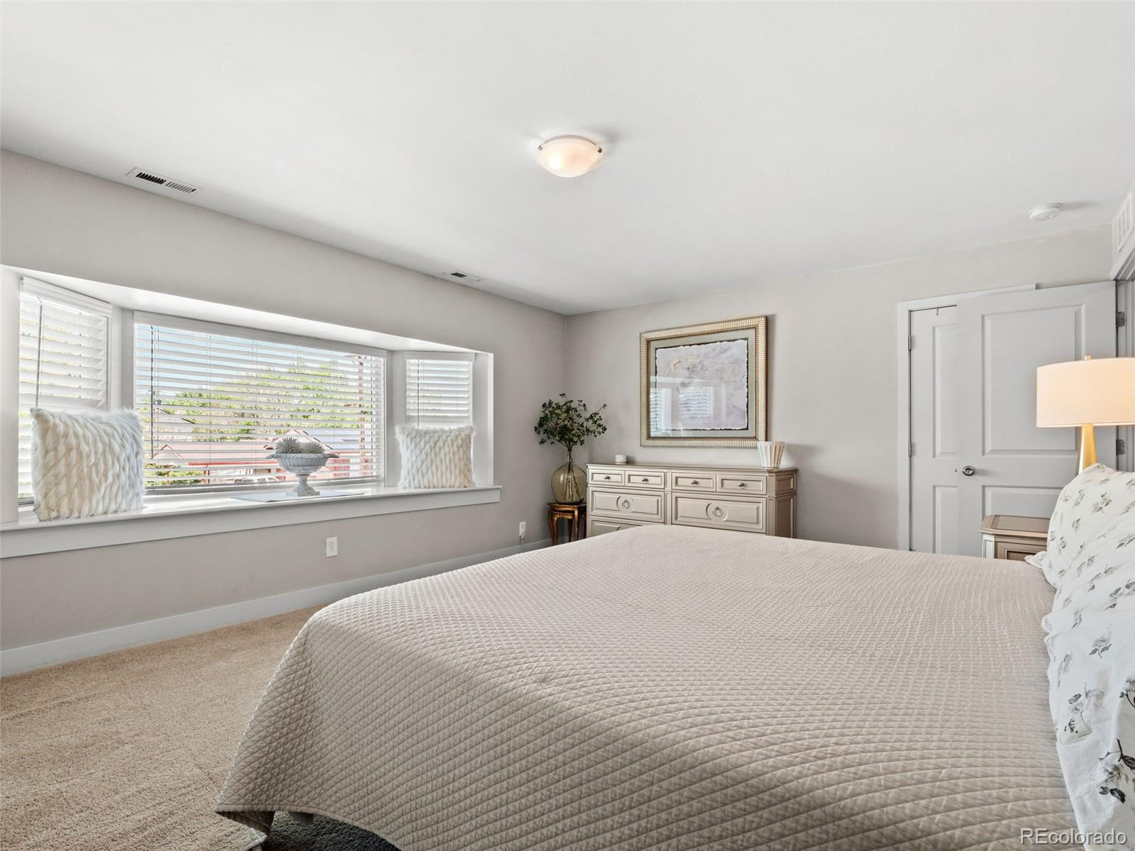 6595 West 46th Place Wheat Ridge, CO 80033 - Photo 27 of 48 a bedroom with a large bed and a large window