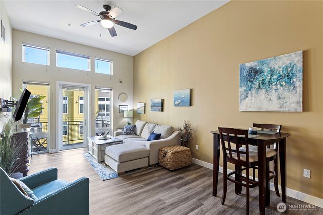 a living room with furniture a flat screen tv and a large window