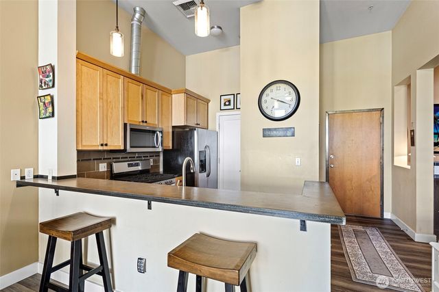 a kitchen with stainless steel appliances granite countertop a sink and a refrigerator