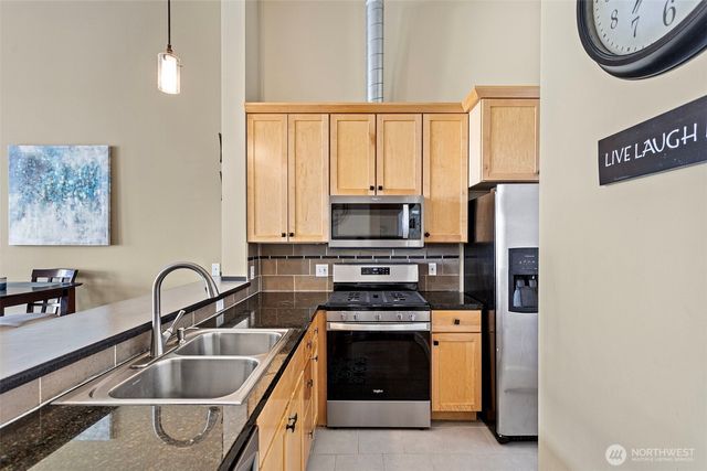 a kitchen with kitchen island a sink appliances cabinets and a counter top space
