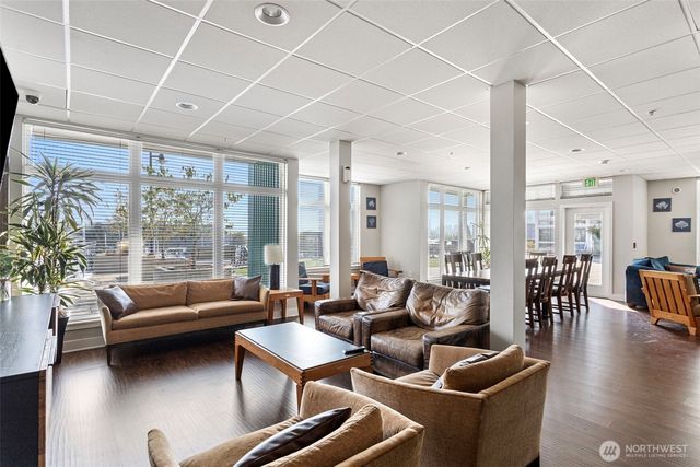 a living room with furniture a flat screen tv and a floor to ceiling window