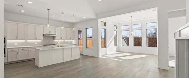 a kitchen with white cabinets and sink