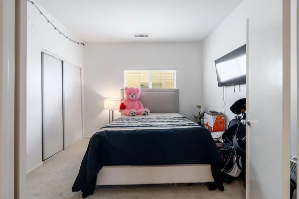 a spacious bedroom with a bed and a flat screen tv