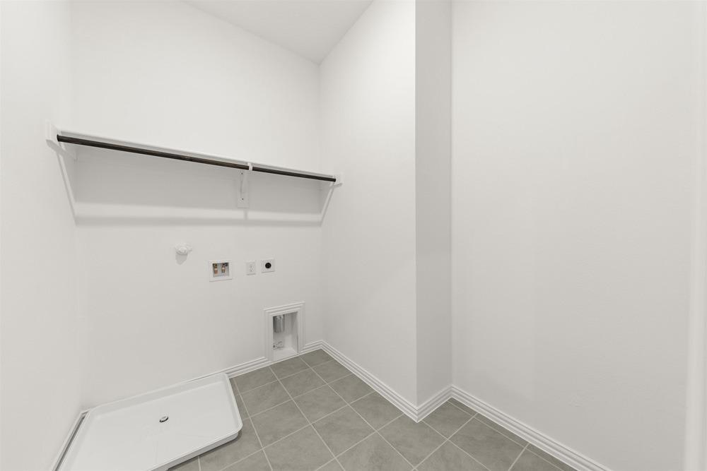 1237 Doris May Drive Allen, TX 75013 - Photo 14 of 19 Laundry area featuring tile flooring, white baseboards, and a white shelf with a hanging rod