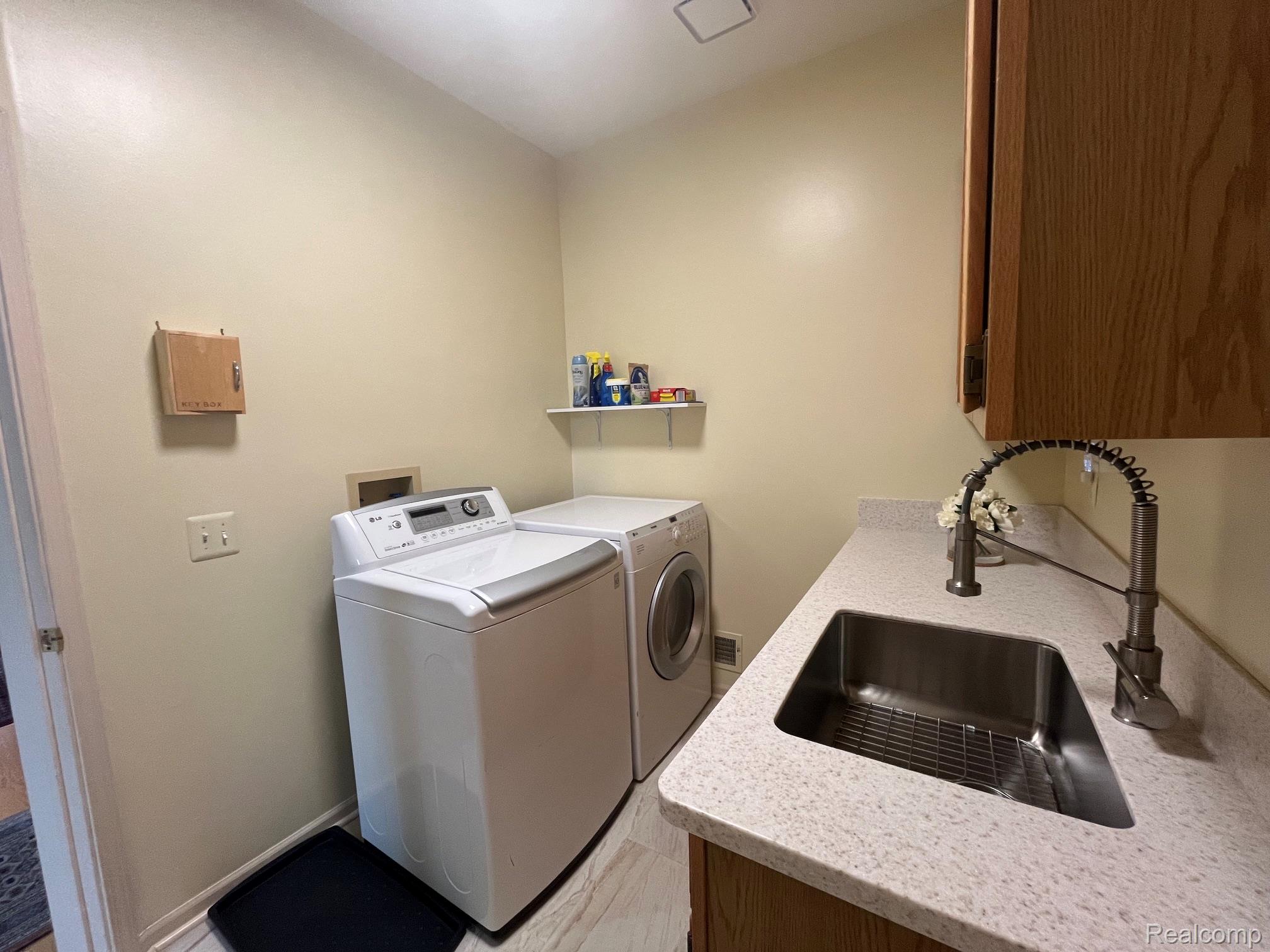 1708 Devonwood Drive Rochester, MI 48306 - Photo 30 of 70 Laundry area featuring a stainless steel sink, pull-down faucet, and light-toned countertop.