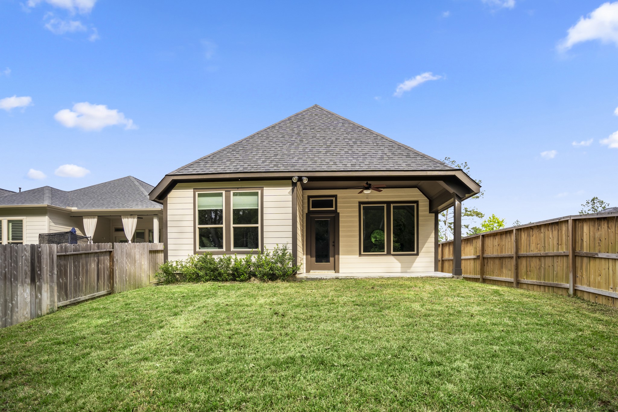 334 Topper Pines Drive Montgomery, TX 77316 - Photo 38 of 49 Looking back toward the home, the covered patio stretches across the rear exterior with room to enjoy the backyard and greenbelt setting from just outside the main living space.