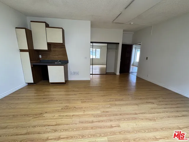 a view of a kitchen with wooden floor and electronic appliances