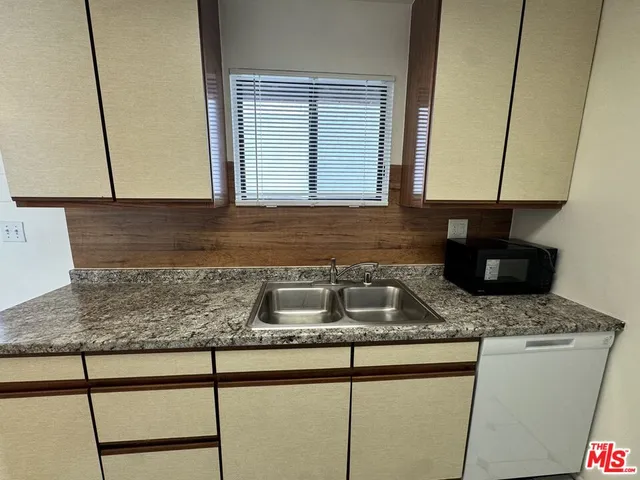 a kitchen with granite countertop a sink a granite counter tops and a stove