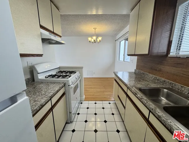 a kitchen with granite countertop a stove and a sink