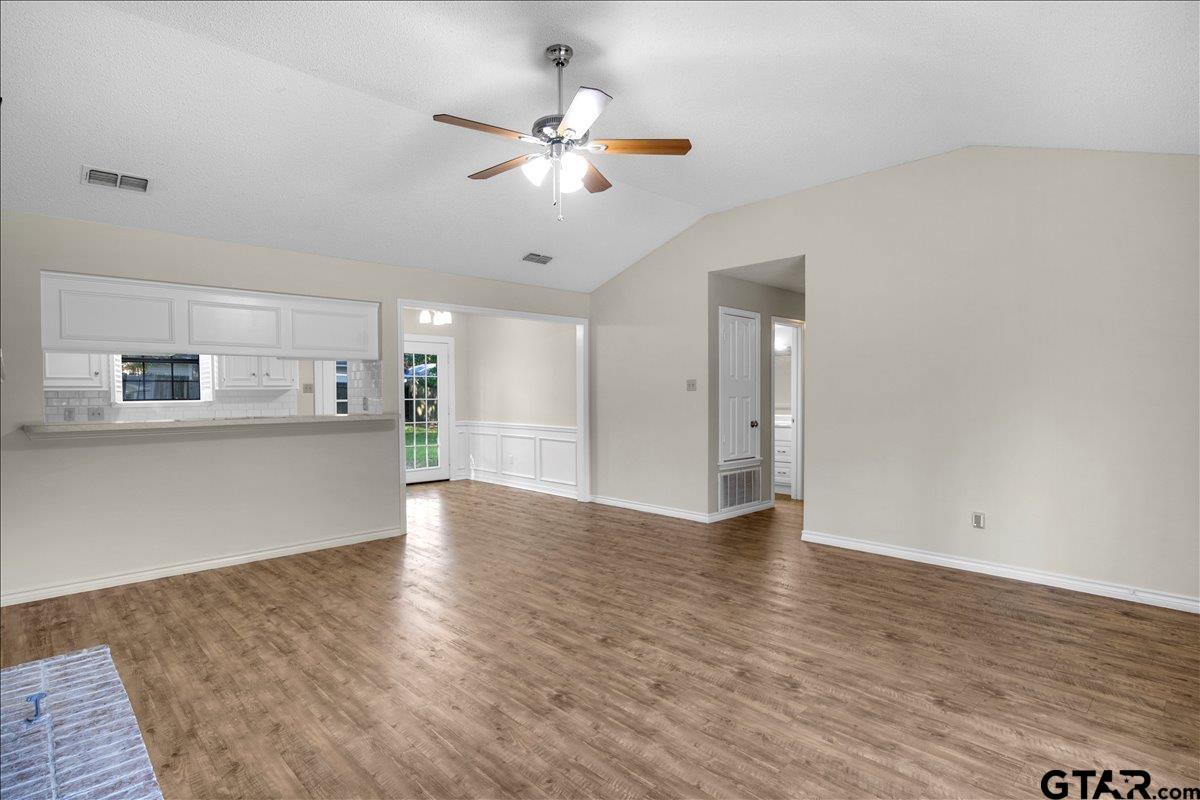 3325 McDonald Road Tyler, TX 75701 - Photo 6 of 26 a view of an empty room with kitchen and wooden floor