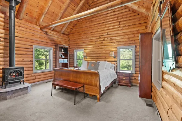 a bed sitting in a spacious bedroom next to a window