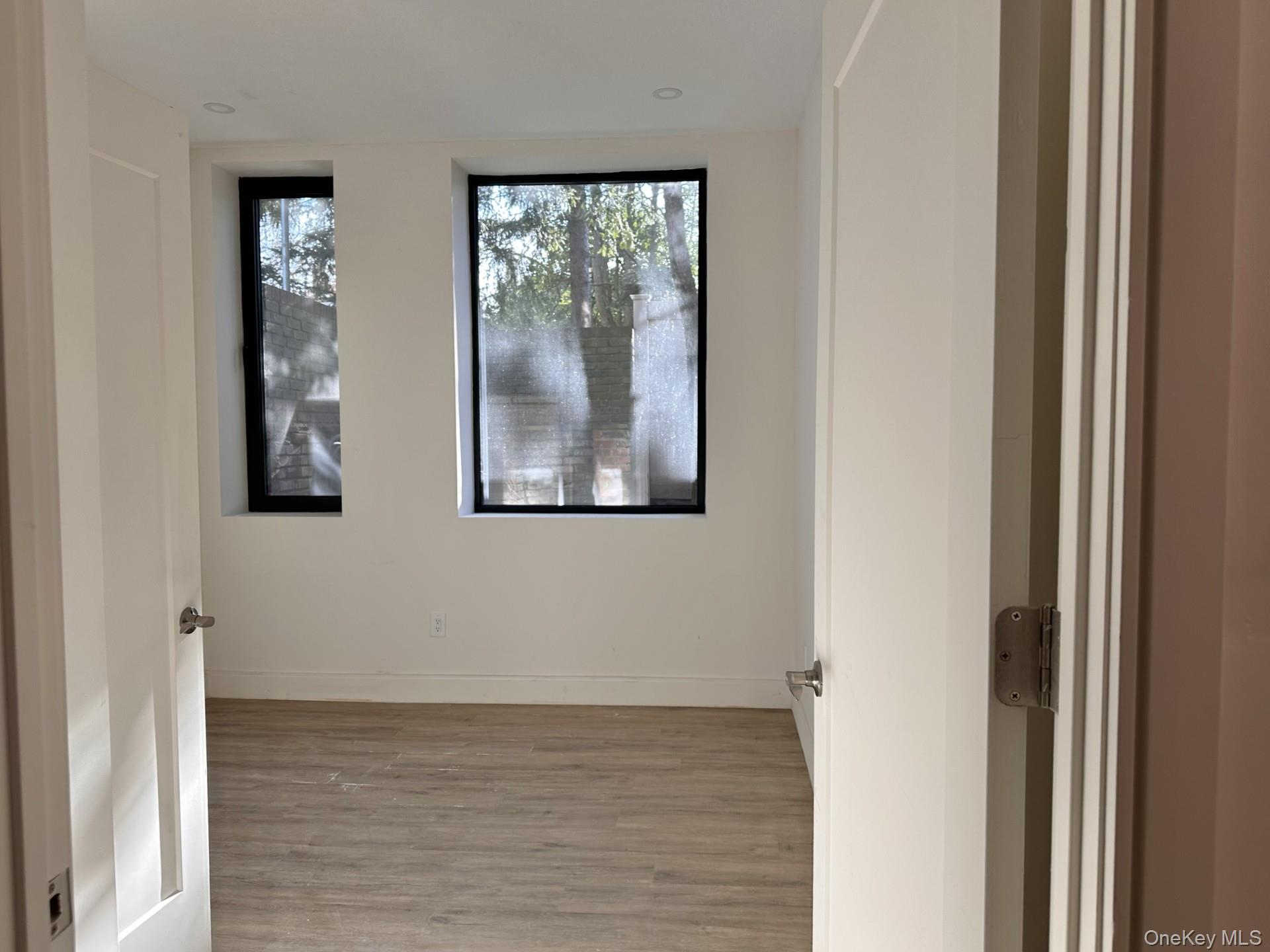 Spare room featuring light wood-style floors and baseboards