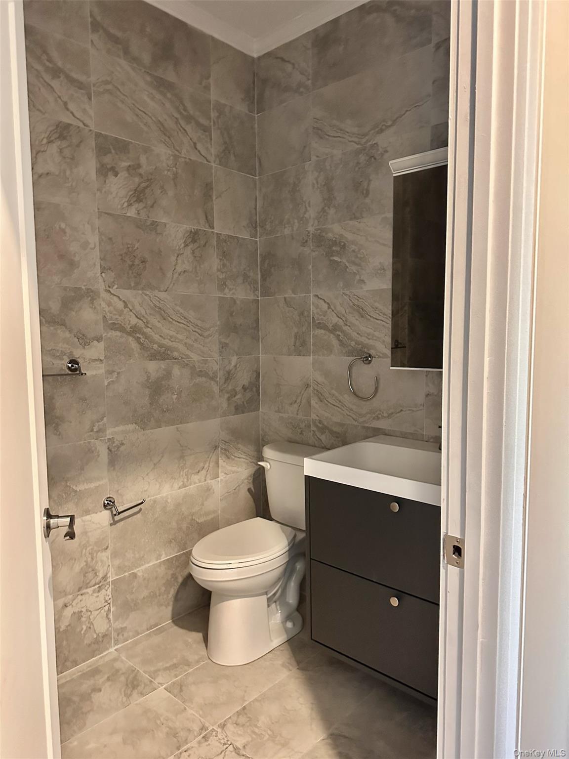 362 West Merrick Road, Unit 104 Valley Stream, NY 11580 - Photo 5 of 11 Half bathroom featuring tile walls and vanity