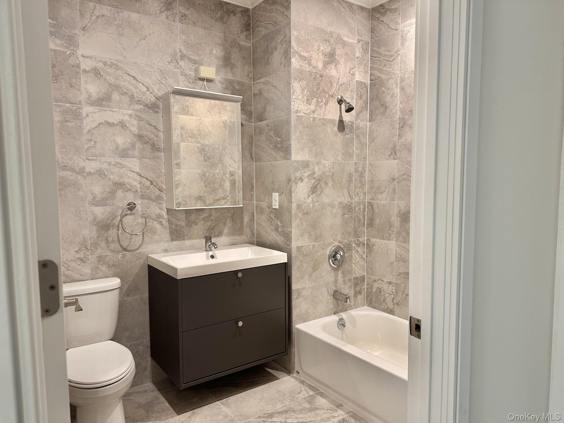 362 West Merrick Road, Unit 104 Valley Stream, NY 11580 - Photo 6 of 11 Bathroom featuring vanity, shower / tub combination, tile walls, and marble look tiles