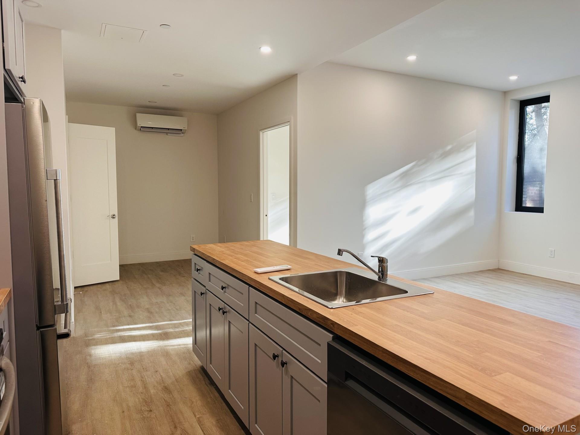362 West Merrick Road, Unit 104 Valley Stream, NY 11580 - Photo 8 of 11 Kitchen with freestanding refrigerator, wood counters, light wood-style flooring, gray cabinetry, and dishwasher