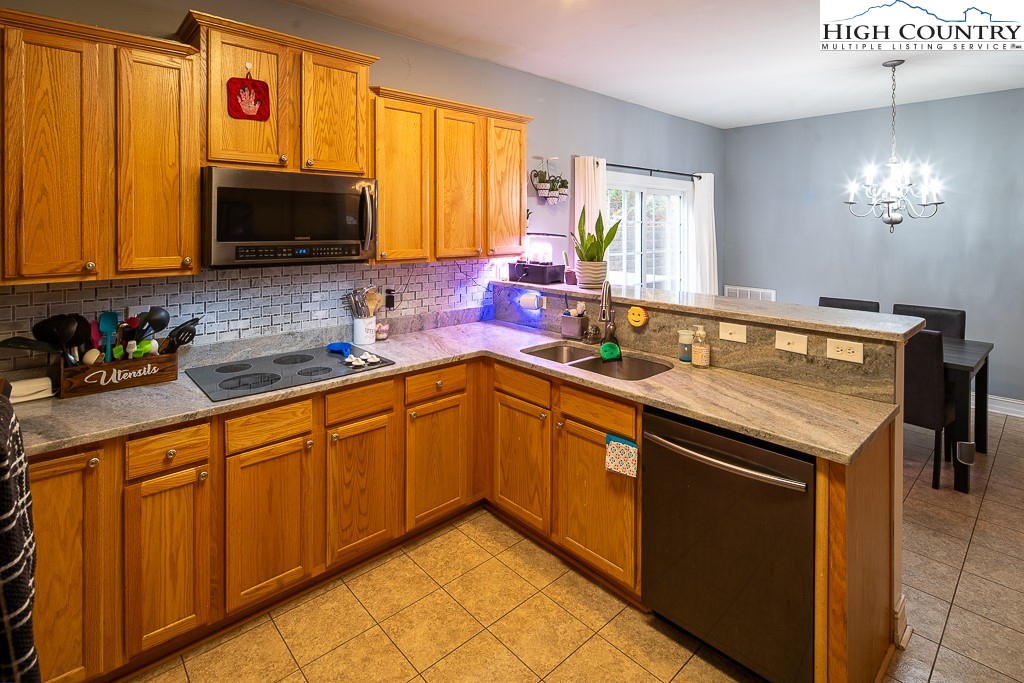 778 Roby Poe Road Crumpler, NC 28617 - Photo 17 of 50 a kitchen with stainless steel appliances granite countertop a sink dishwasher stove and microwave