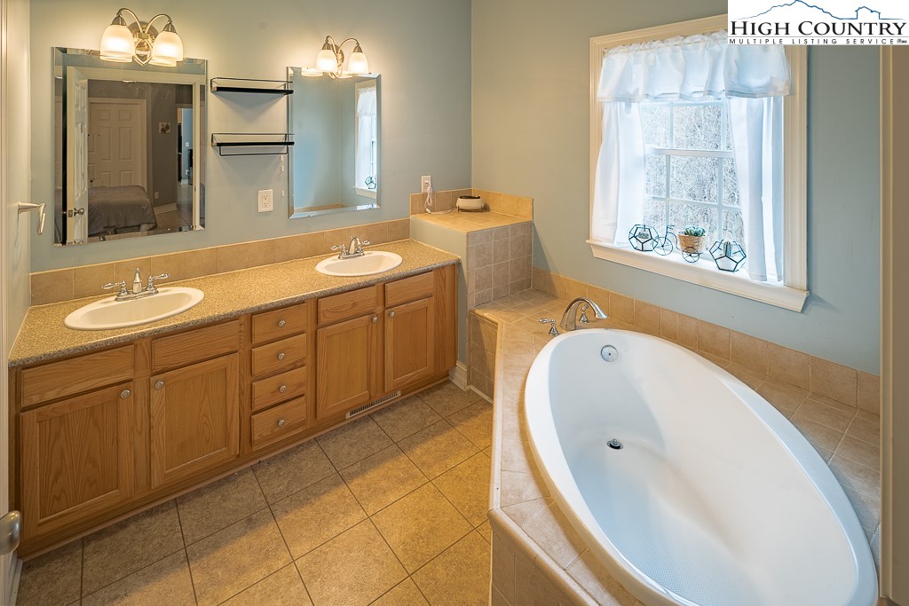 778 Roby Poe Road Crumpler, NC 28617 - Photo 24 of 50 a bathroom with a tub sink and mirror
