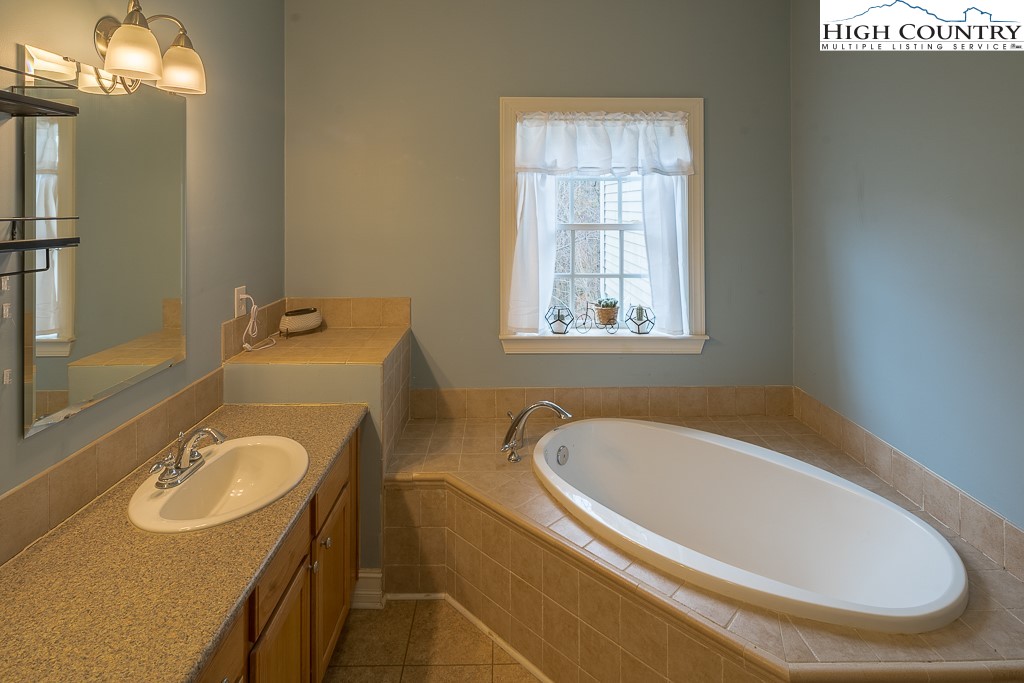 778 Roby Poe Road Crumpler, NC 28617 - Photo 25 of 50 a bathroom with a tub sink and mirror