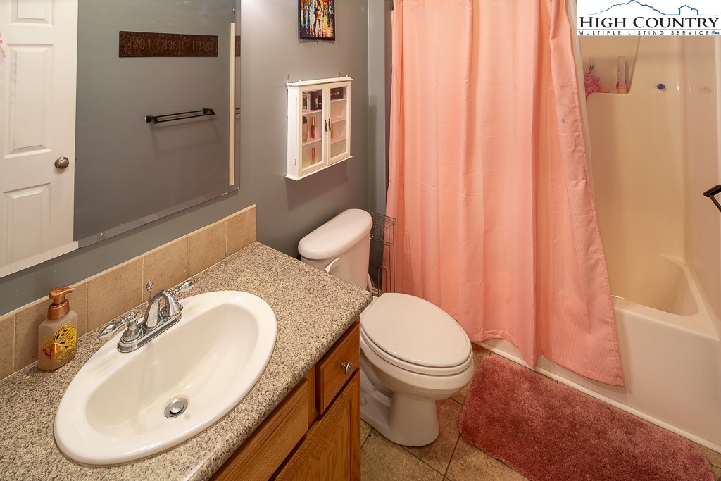 778 Roby Poe Road Crumpler, NC 28617 - Photo 28 of 50 a bathroom with a sink a toilet and shower curtain