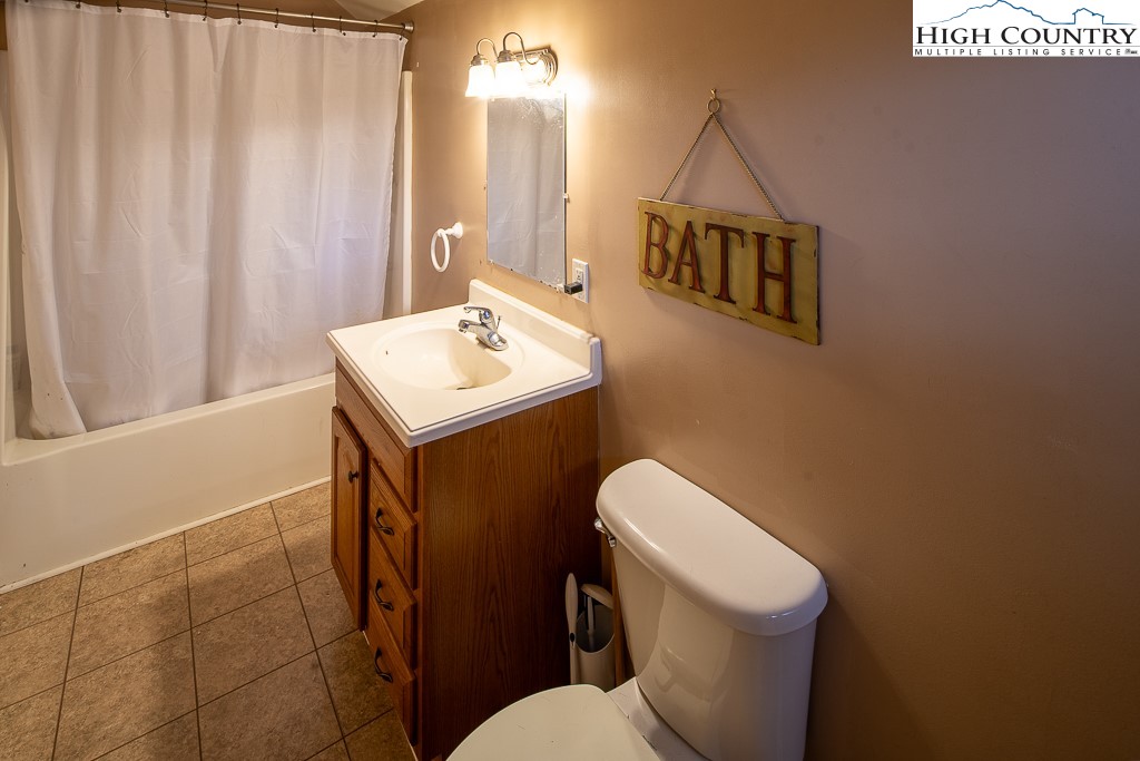 778 Roby Poe Road Crumpler, NC 28617 - Photo 33 of 50 a bathroom with a toilet a sink and a shower