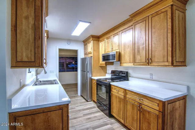 a kitchen with stainless steel appliances a sink stove and cabinets