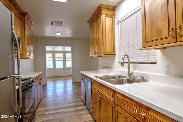 a kitchen with a sink and wooden floor