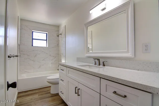 a bathroom with a granite countertop toilet a sink and a bathtub