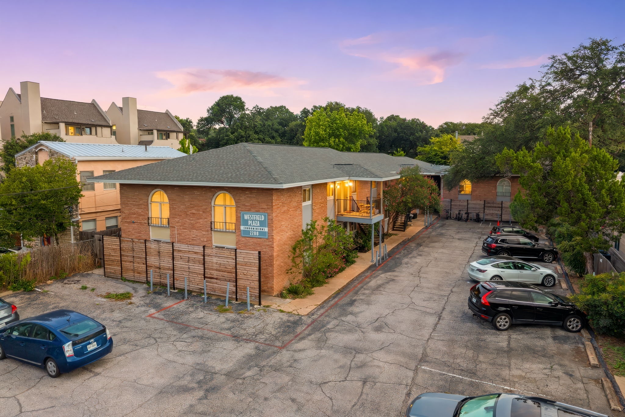 2208 Enfield Road, Unit 107 Austin, TX 78703 - Photo 3 of 35 Warm brick construction and structured rooflines define this multi-family residential building.