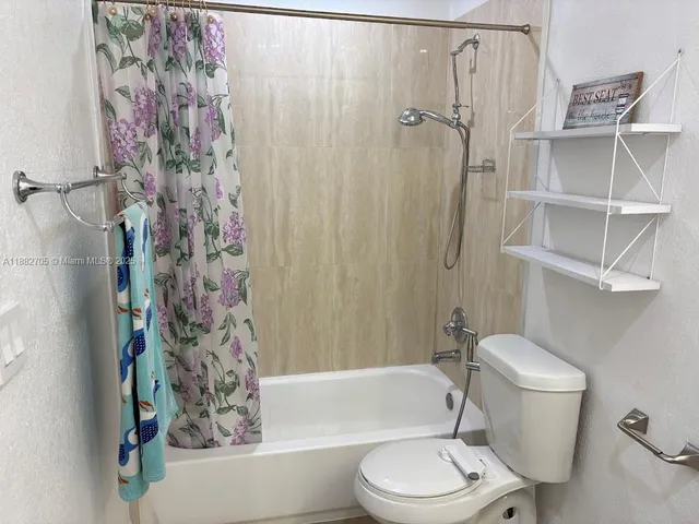 a bathroom with a toilet and a shower curtain