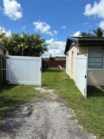 a view of a backyard with a garden and chairs