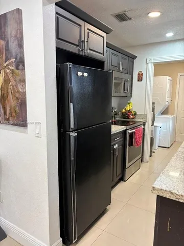 a kitchen with stainless steel appliances granite countertop a refrigerator and a sink