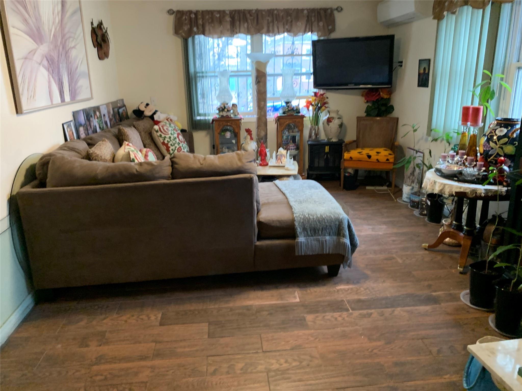 87-33 Commonwealth Boulevard Queens, NY 11426 - Photo 18 of 28 a living room with furniture and a flat screen tv