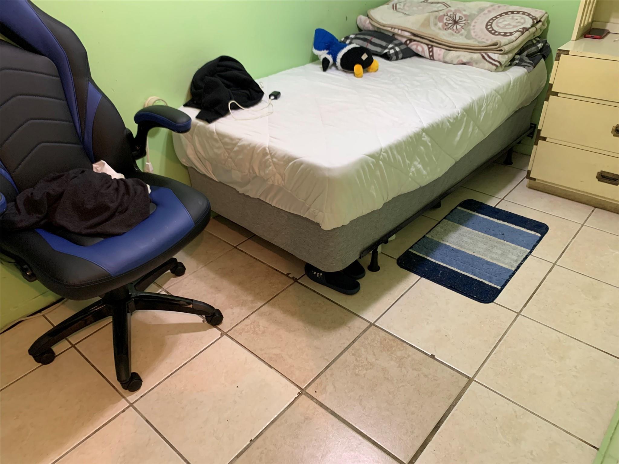 87-33 Commonwealth Boulevard Queens, NY 11426 - Photo 24 of 28 a bed sitting in a bedroom next to a window