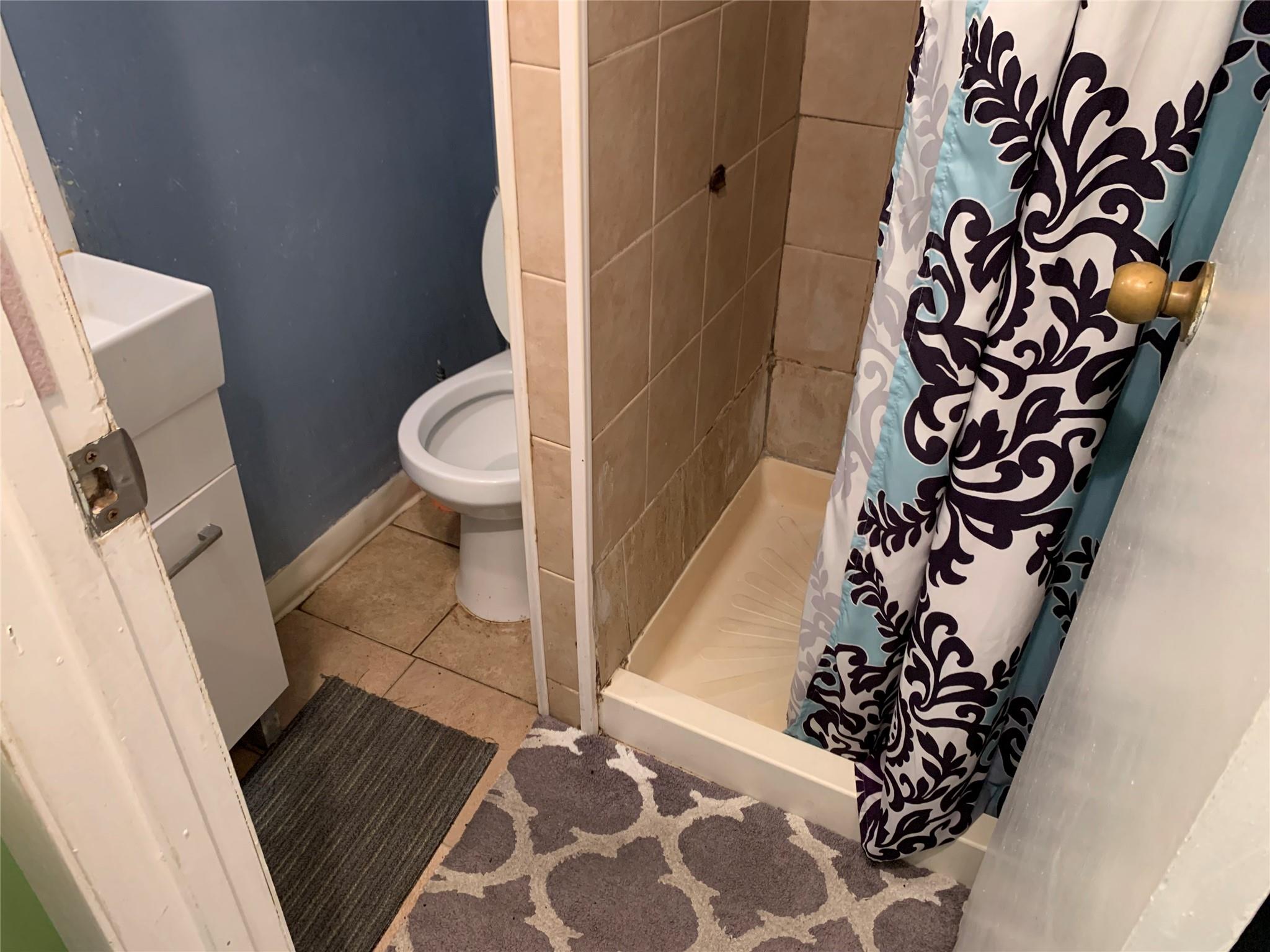 87-33 Commonwealth Boulevard Queens, NY 11426 - Photo 26 of 28 a bathroom with a toilet and a shower curtain