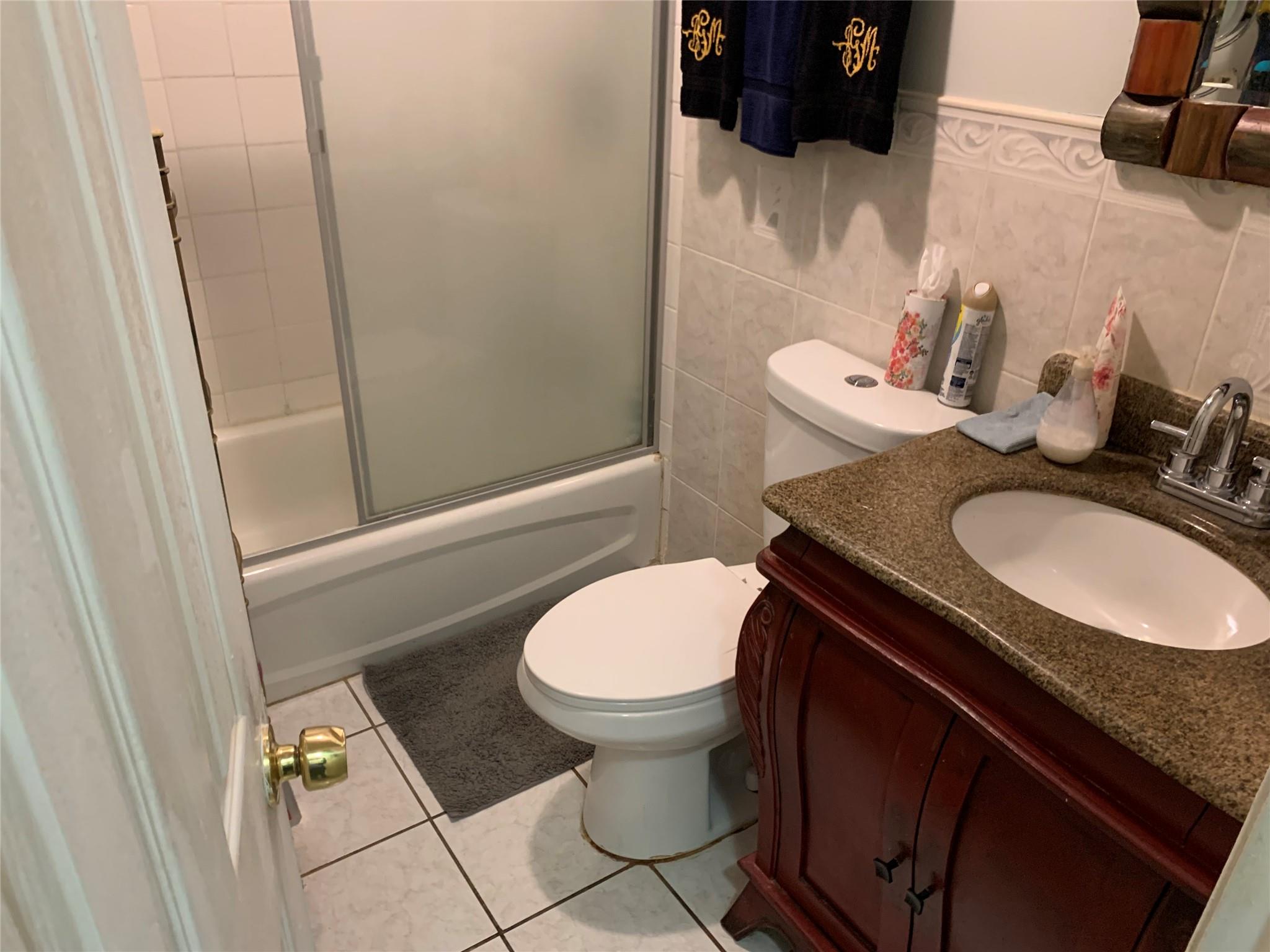 87-33 Commonwealth Boulevard Queens, NY 11426 - Photo 28 of 28 a bathroom with a granite countertop toilet and a sink