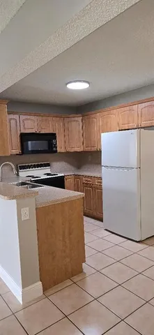 a kitchen with stainless steel appliances a refrigerator sink and microwave
