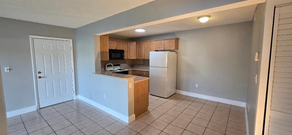 301 Palm Way, Unit 107 Pembroke Pines, FL 33025 - Photo 5 of 36 a kitchen with a refrigerator and a stove top oven