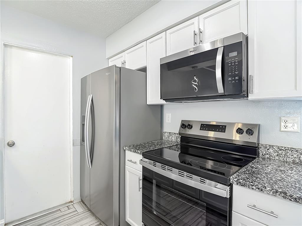 13156 Odham Street Spring Hill, FL 34609 - Photo 12 of 54 a kitchen with a stove microwave and refrigerator