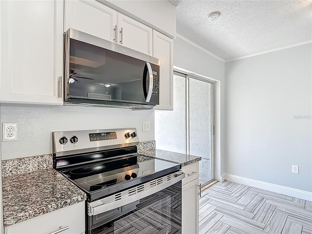 13156 Odham Street Spring Hill, FL 34609 - Photo 13 of 54 a kitchen with a stove and a microwave